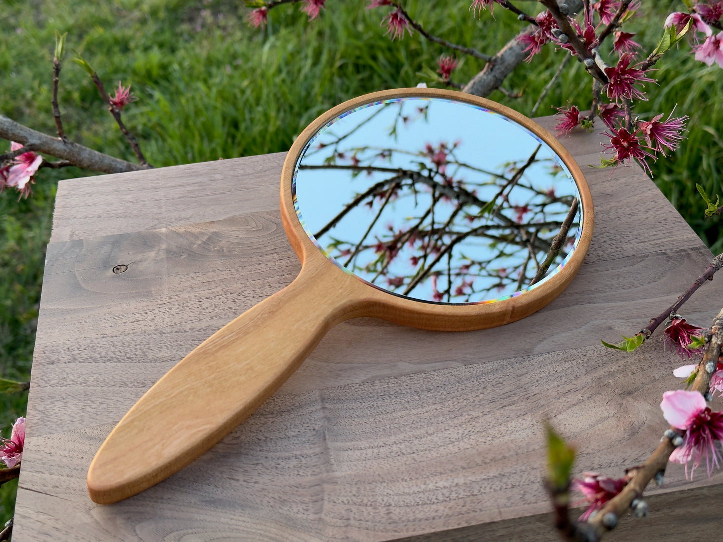 Wood hand mirror made from solid cherry hardwood. Front  view shown featuring a 6 inch beveled glass mirror.