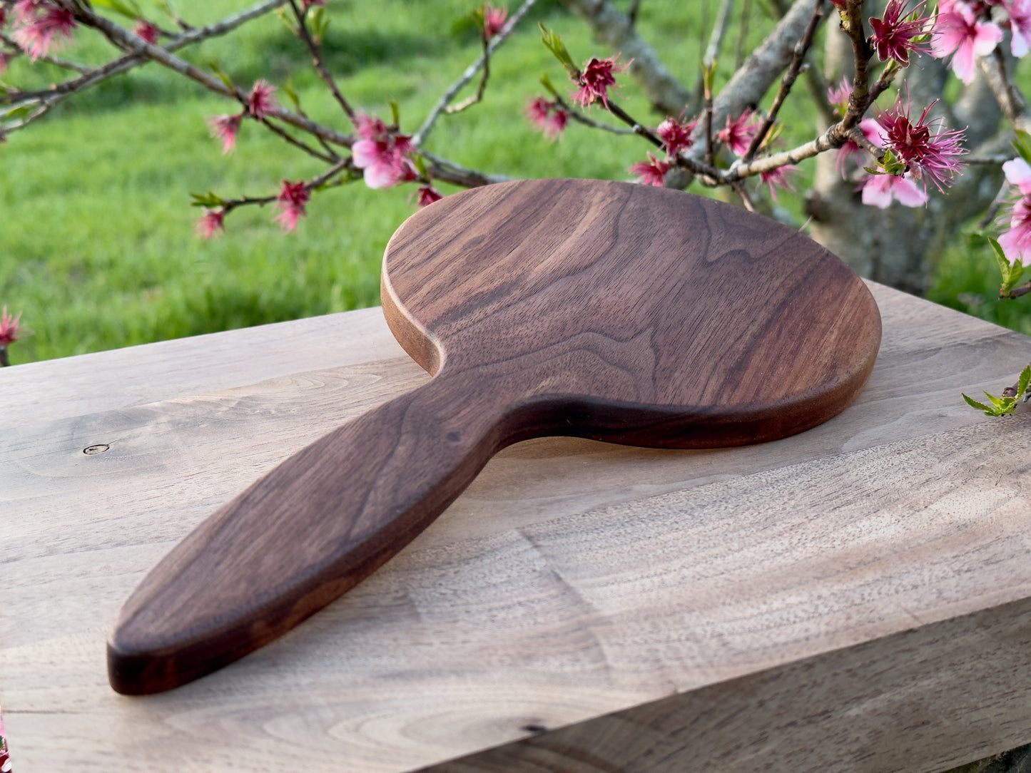Wood hand mirror made from solid black walnut hardwood. Back view shown featuring a 6 inch beveled glass mirror.