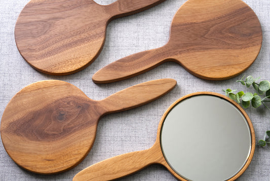 Black Walnut Hand Mirrors with 6 inch beveled glass. 4 mirrors shown with 3 facing down and one showing the mirror. Features highly figured solid walnut 