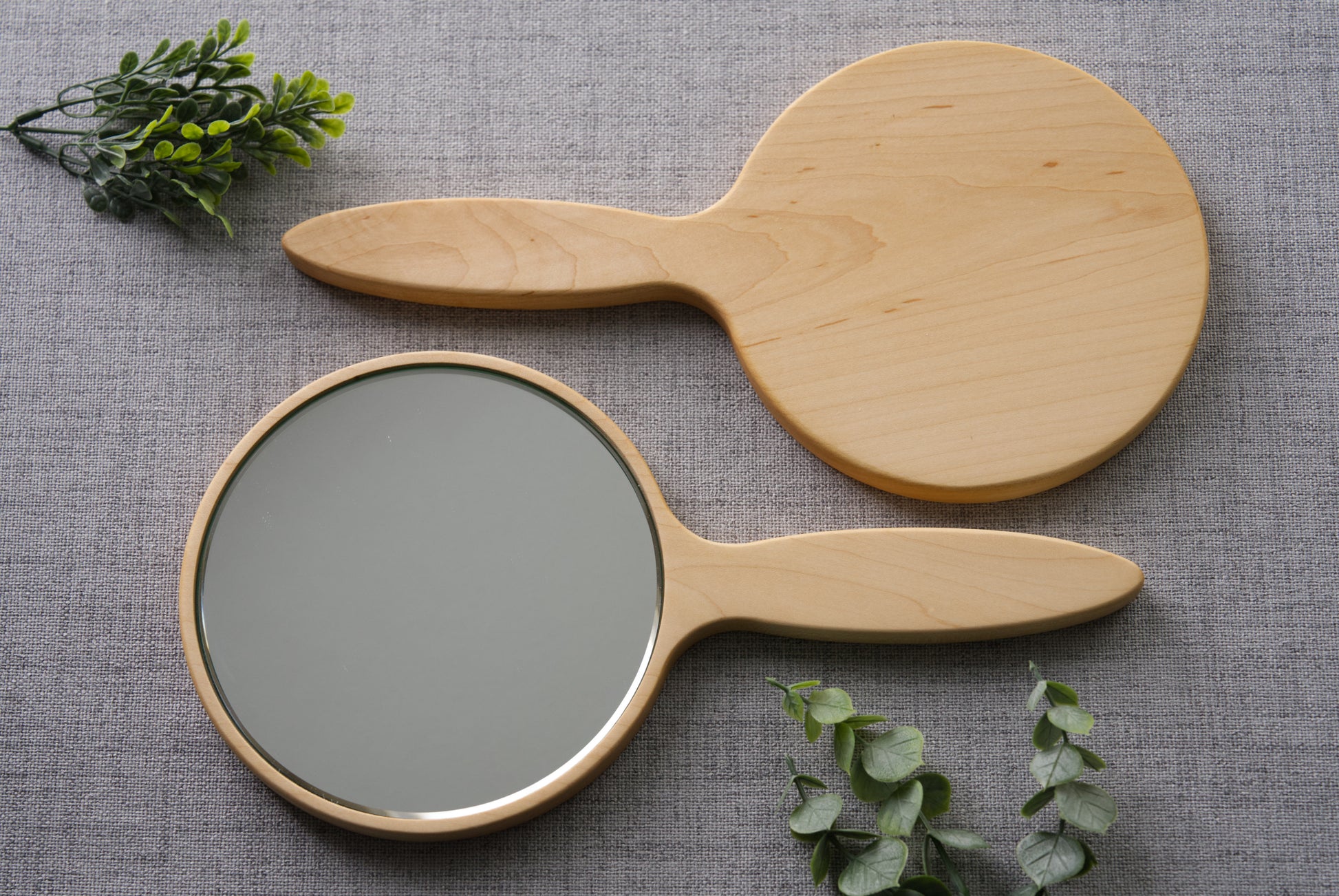 Wood hand mirror made from solid hard maple hardwood. Front and back view shown featuring a 6 inch beveled glass mirror.