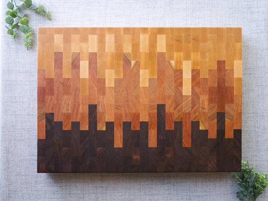 Ombre End Grain Cutting board made from domestic black walnut, maple and cherry. Shown on grey cloth table and is finished with mineral oil and beeswax